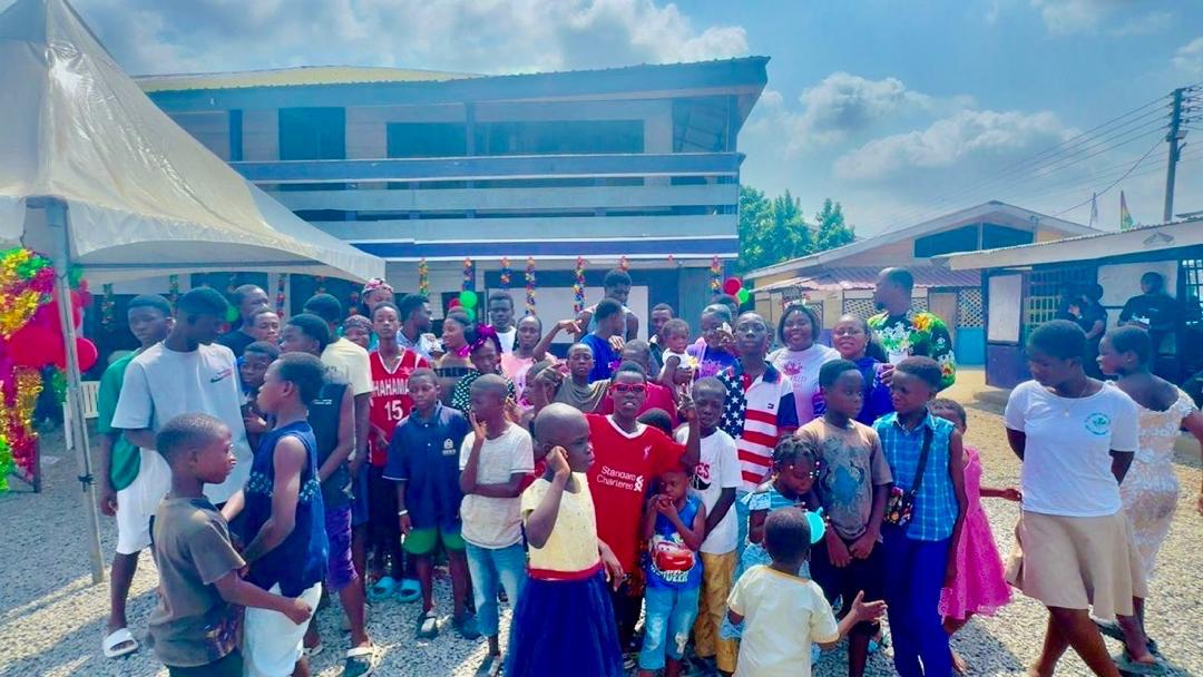 Children celebrating with volunteers at a decorated outreach event