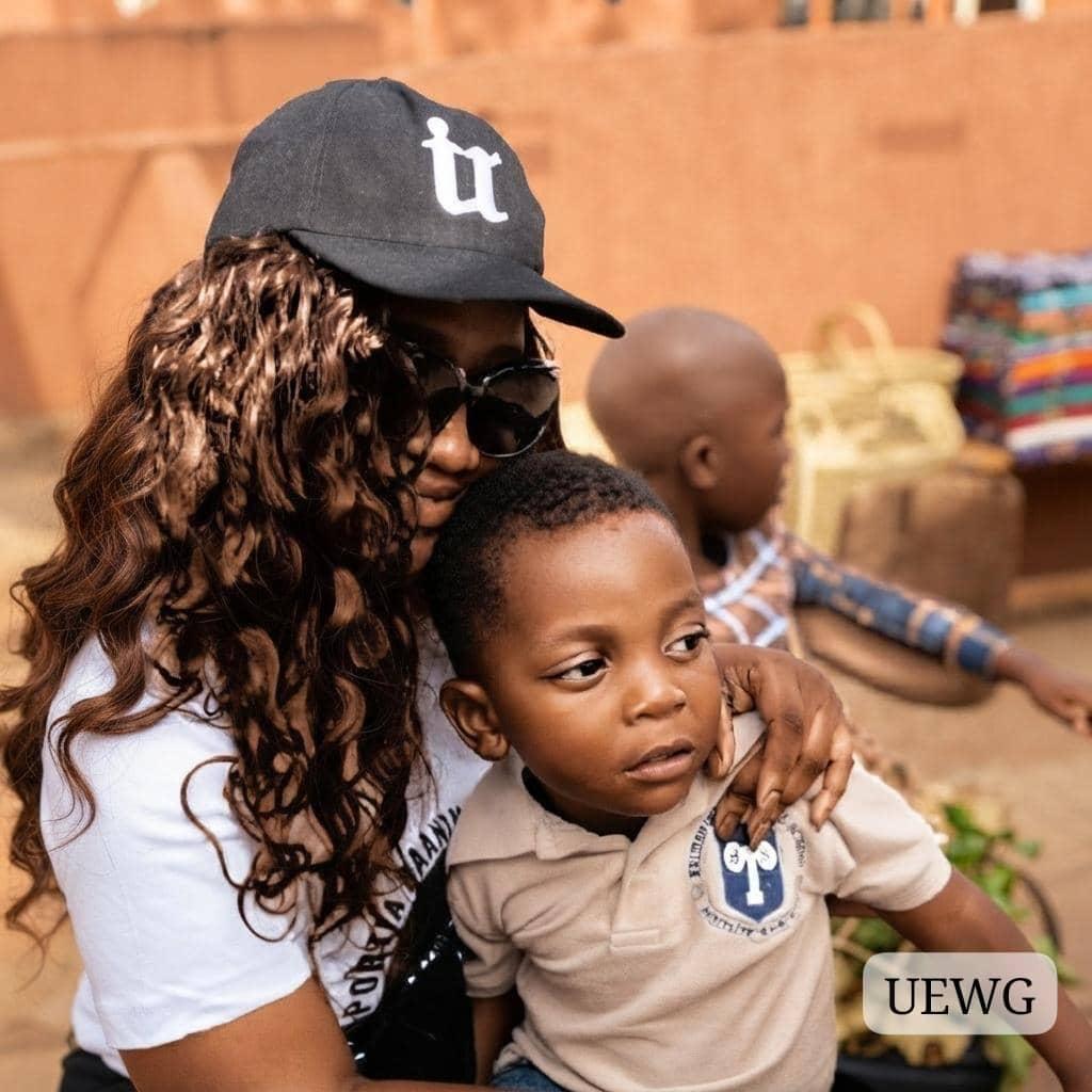UEWG volunteer holding a child at an outreach
