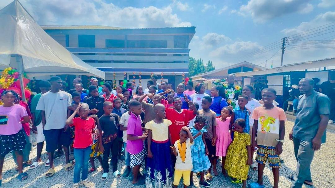 Large group of children and UEWG volunteers outside an orphanage home
